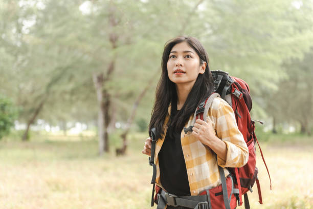 istock Beautiful Asian backpacker woman walking into the forest. 1395475074