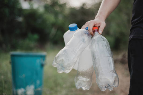 istock A man holds a used plastic bottle for recycling in his hand. 1395478969