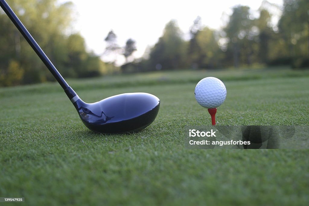 golf 7 Golf ball sitting on red tee with driver next to it Golf Course Stock Photo