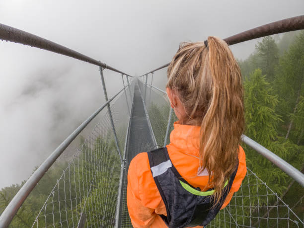 istock Female trail runner crossing suspension ridge 1395479323