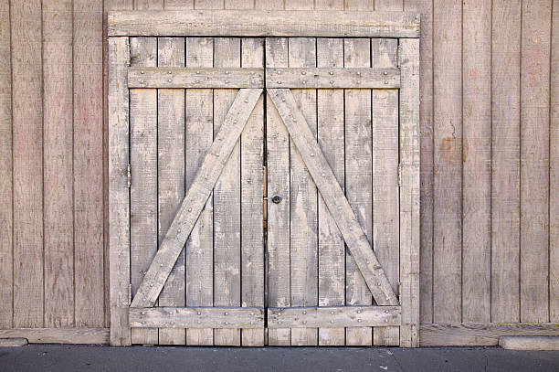 Doorway of wood Weathered wood doorway in wooden wall. barn doors stock pictures, royalty-free photos & images