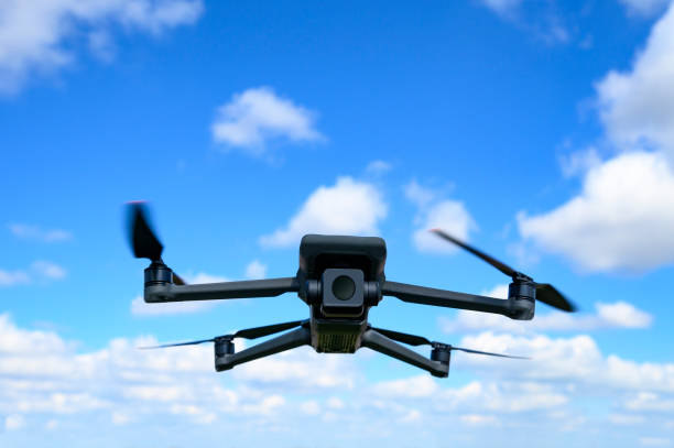istock Drone flying in the air with a blue sky in the background. 1395480940