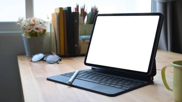istock Digital tablet with wireless keyboard on wooden table at home office. 1395484302