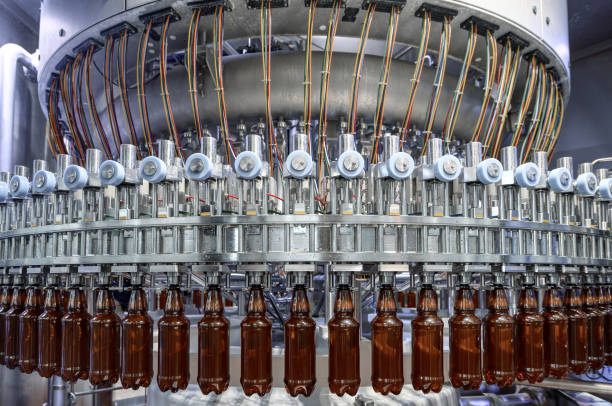 riempimento di bottiglie di plastica con varie bevande su una riempitrice automatica - bottling plant brewery industry food foto e immagini stock