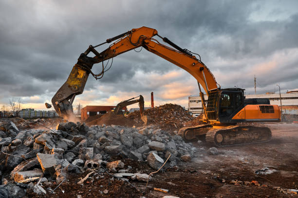 istock Excavator with crusher presses pile of reinforced cement 1395488219