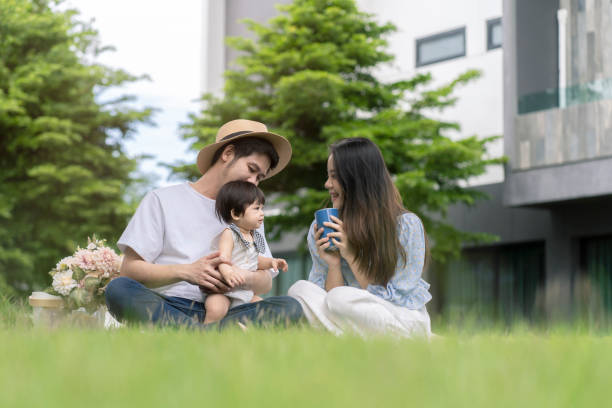 Asian Parents and a kid child playing in the garden at home. Family concept. stock photo