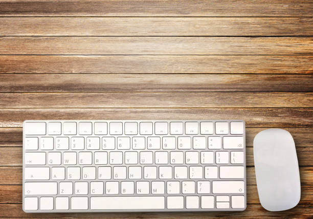 istock Top view with mini wireless keyboard and mouse on brown wood table background. 1395489645
