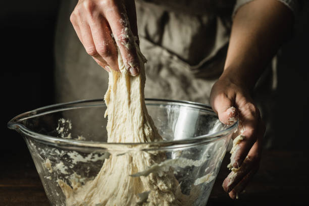 mani di donna che impastano l'impasto per preparare il pane in una ciotola - bread kneading making human hand foto e immagini stock