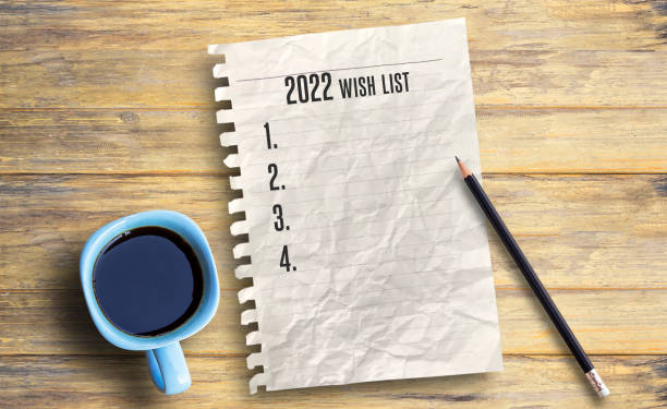 istock Text for 2022 wishlist and paper on wood table background. 1395490416