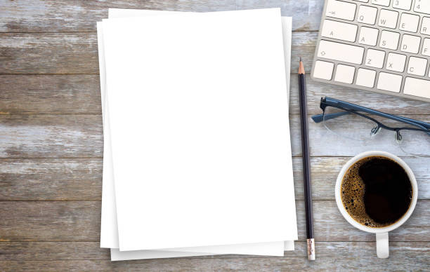 istock White paper or notepad with pencil and mini keyboard,cofee on wood table background.using wallpaper for education, business photo. 1395490500