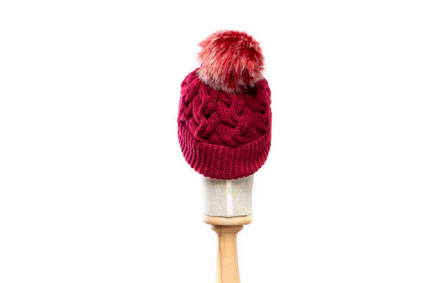 Red knit beanie with mannequin head on white background stock photo