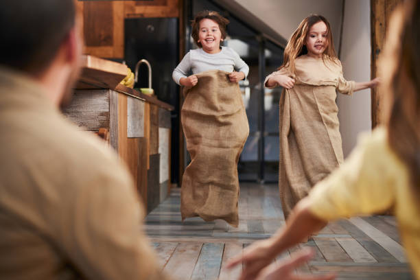 corrida de saco em casa! - child playing sack race sports race - fotografias e filmes do acervo