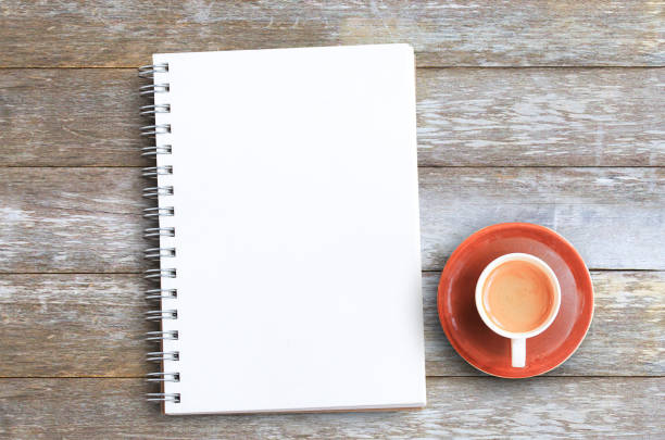 istock Top view with coffee cup and notebooks on wood table in office 1395492561