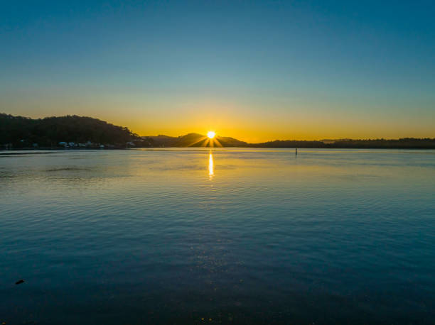 Aerial sunrise at the waterfront with a cloudless sky at Woy Woy on the Central Coast, NSW, Australia.