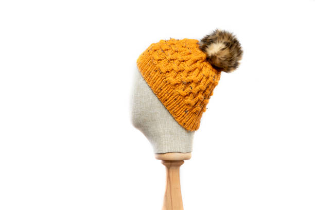 istock Mustard knit beanie with mannequin head on white background 1395493225