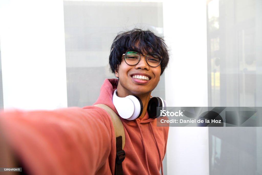 Asian adolescent male taking selfie with phone looking at camera. Teen boy college students take photo of himself. Asian adolescent male taking selfie with phone looking at camera. Teen boy college students take photo of himself. Technology and social media concept. Generation Z Stock Photo