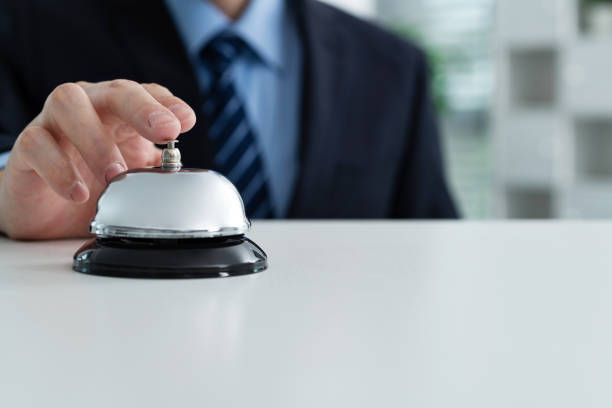 Businessman hand ringing a service bell.