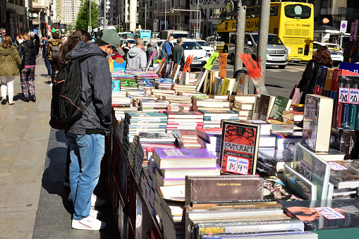Madrid, Spain - April 21, 2022. A man looks at books in a street stall