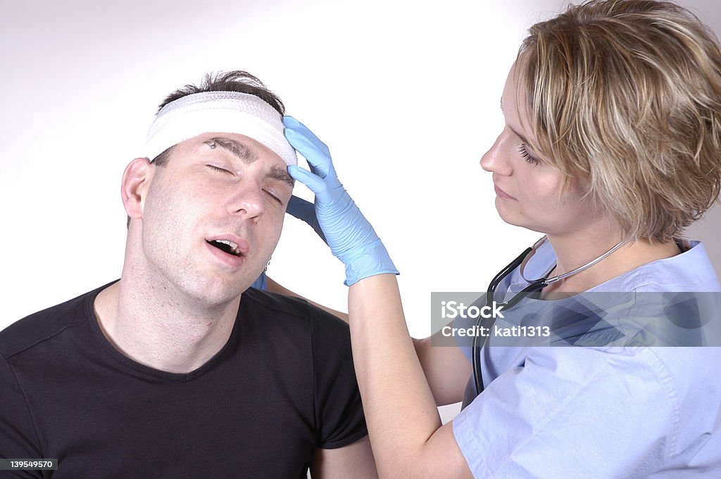 head injury nurse bandaging the head of a patient Accidents and Disasters Stock Photo