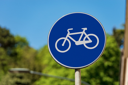 Close-up of a blue road sign of a cycle path in the center of an Italian city. Italy, Europe. Photography.