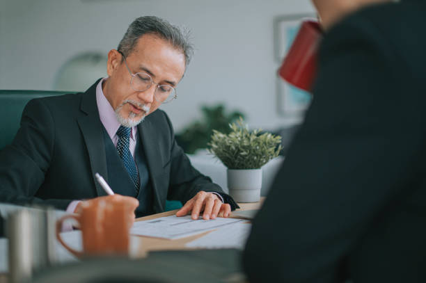 istock Asian CEO businessmen signing document agreement in office 1395496646