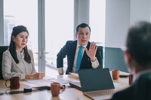 disaccordo sull'argomento del capo dipartimento asiatico nella sala riunioni - ceo serious board room manager foto e immagini stock