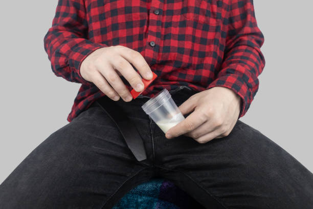 Suitability test for artificial insemination. Man takes semen analysis. Spermogram. Concept. Male with his pants unbuttoned symbolizes preparation for analysis of seed for infertility, sperm motility. el hombre toma análisis de semen. espermograma. concepto. el macho con los pantalones desabrochados simboliza la preparación para el análisis de la semilla para la infertilidad, la motilidad de los espermatozoides. prueba de idoneidad para la inseminaci