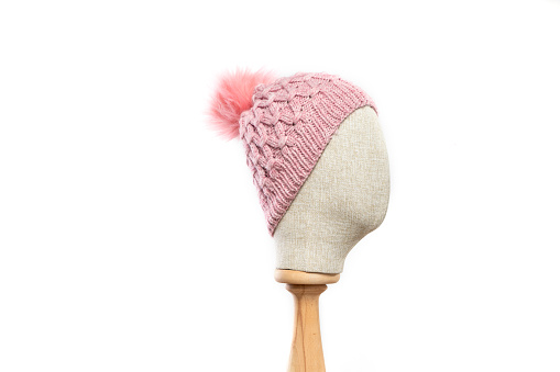 Pink knit beanie with mannequin head on white background