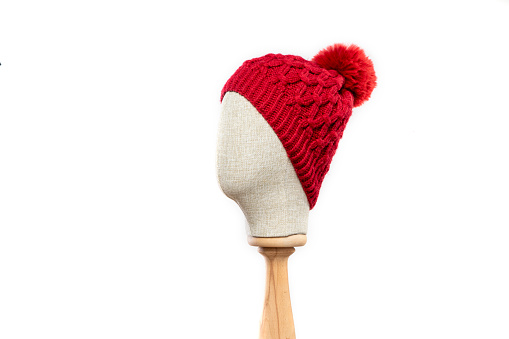 Red knit hat/beanie with mannequin head on white backgroundPink knit beanie with mannequin head on white background