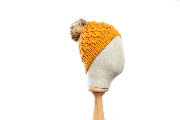 istock Mustard knit beanie with mannequin head on white background 1395502624