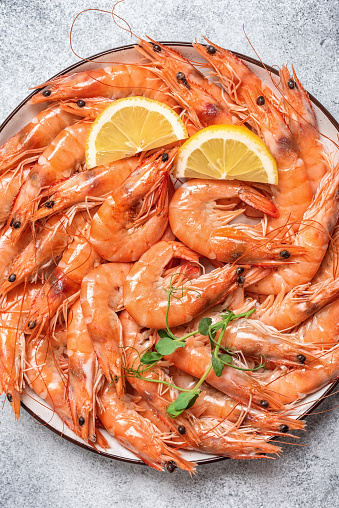 Boiled tiger prawns in a plate close-up. Top view, vertical. Red shrimp.