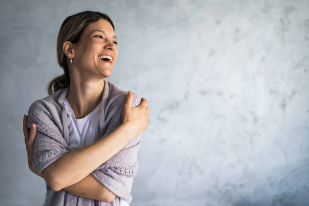 istock Smiling loving young woman hugging oneself 1395504518