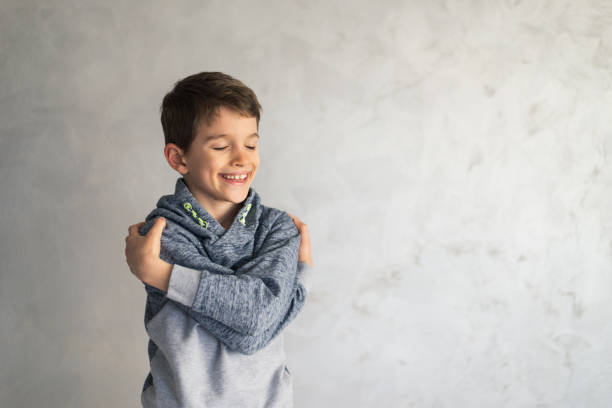 istock Smiling loving young boy hugging oneself 1395504562