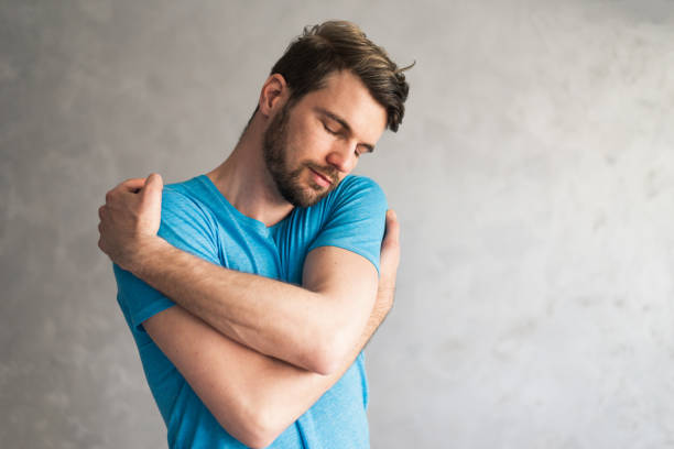 istock Smiling loving young man hugging oneself 1395504627