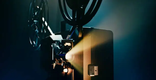 Close-up of old cinema projector with beam of light.