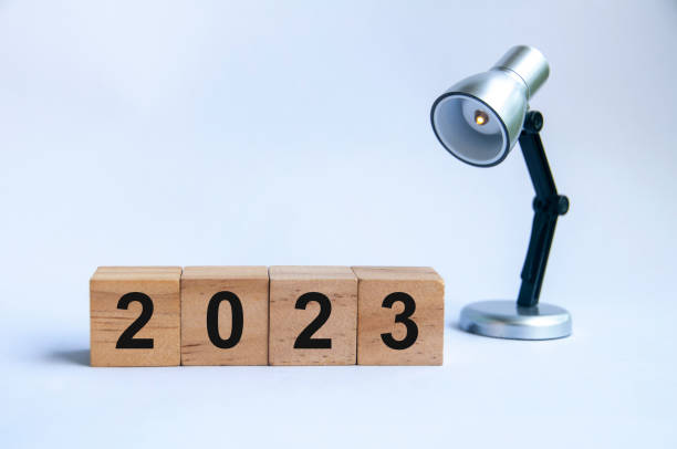 istock Year 2023 on wooden blocks with silver lamp background. 1395510209