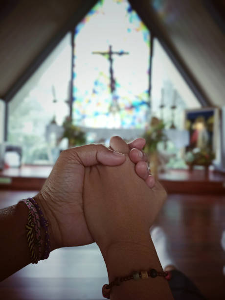 holding hands of faithful mom and daughter against the altar in the church with blurry background jesus christ holy cross. - jesus christ human hand god consoling imagens e fotografias de stock