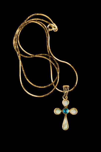 Blue topaz and nacre cross necklace isolated on black background