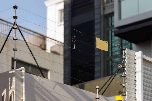 high voltage security fence on house wall with blank yellow plastice sign.