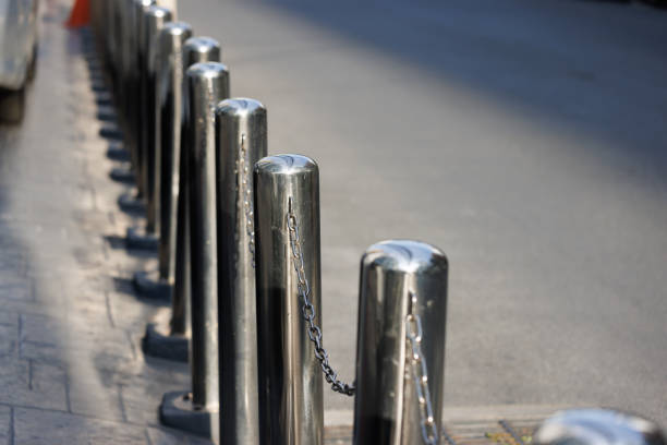istock stainless steel bolloards with chain near road. 1395515731