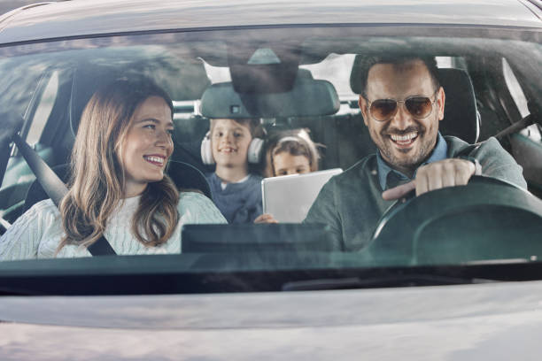 istock Happy family enjoying while going on a vacation by car. 1395515947