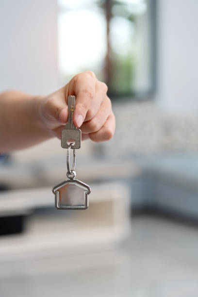 istock Human hand holding a house key 1395516009