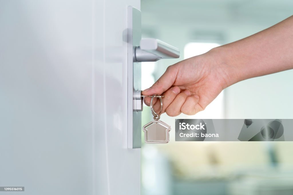 Human hand opening a door with key Human hand opening a door with key. Door Stock Photo