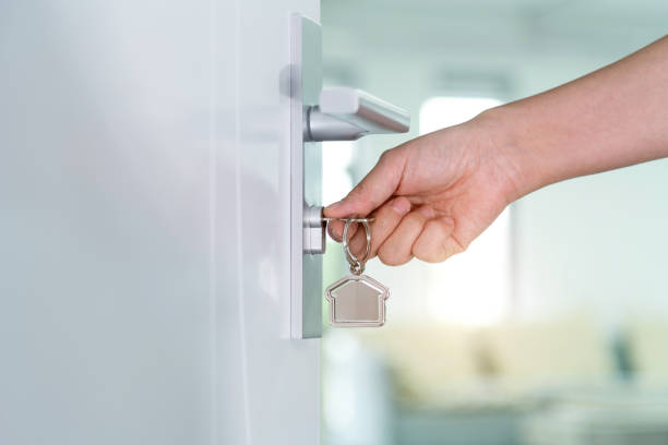 Human hand opening a door with key stock photo