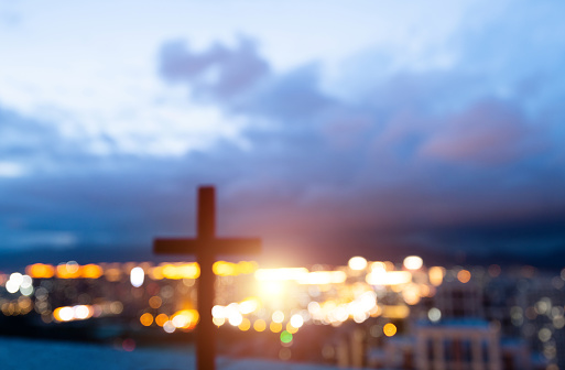 Religious cross on city background.