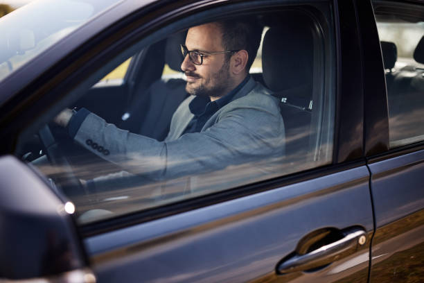 istock Smiling businessman going on a trip by car. 1395517611