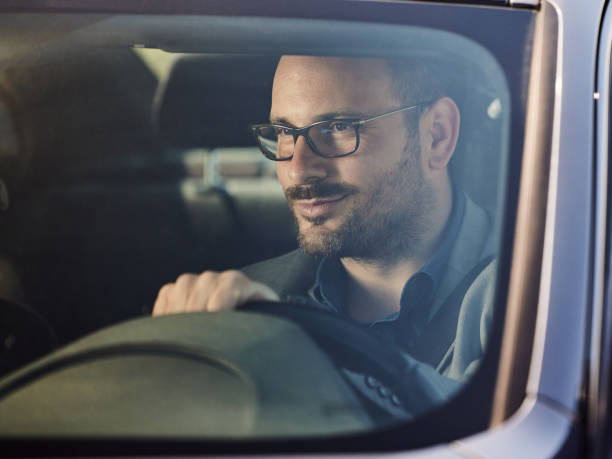 istock Smiling businessman going on a trip by car. 1395517647