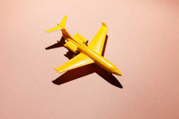 dark yellow toy airplane on pink background