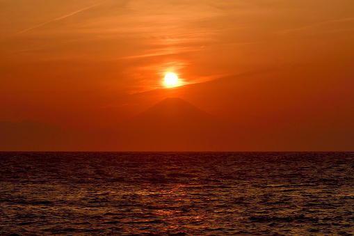 The sun is setting in over Mt. Fuji (so-called Diamond Fuji) and after sunset. \nThe photo was taken at Jogashima, located at the tip of Miura Peninsula, Kanagawa Prefecture.\nWeather permitting, you can enjoy this kind of view twice a year from various parts of the peninsula.