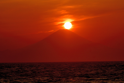 The sun is setting in over Mt. Fuji (so-called Diamond Fuji) and after sunset. \nThe photo was taken at Jogashima, located at the tip of Miura Peninsula, Kanagawa Prefecture.\nWeather permitting, you can enjoy this kind of view twice a year from various parts of the peninsula.